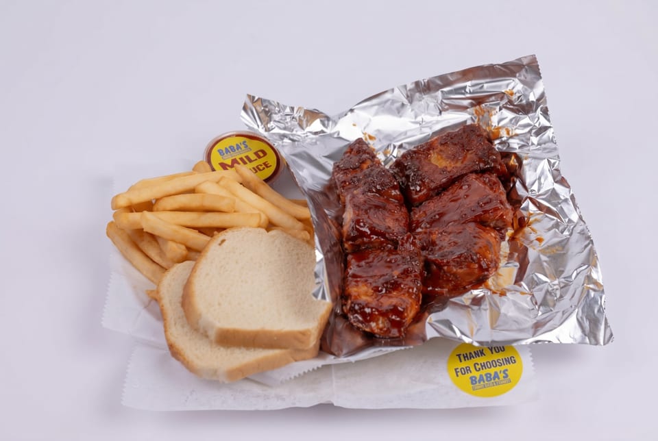 Baba's mild sauce, fries, white bread, and BBQ ribs in foil on a white background.