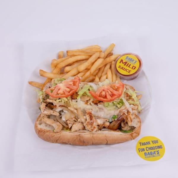 Chicken sub sandwich with lettuce, tomatoes, and fries, with Baba's Mild Sauce.