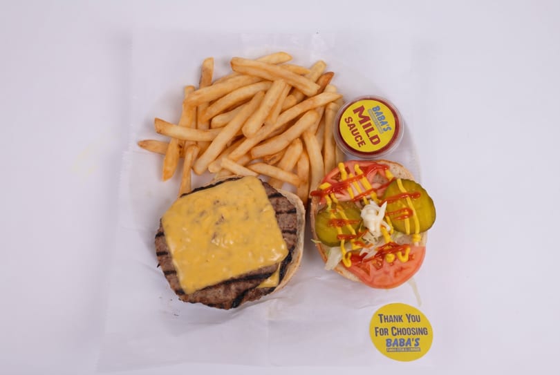 Overhead view of a cheeseburger, fries, Baba's Mild Sauce, and a "Thank You" sticker.