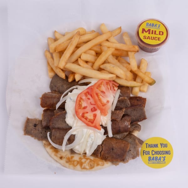 Baba's gyro platter with meat, tomatoes, onions, sauce, and fries, plus a side of mild sauce.
