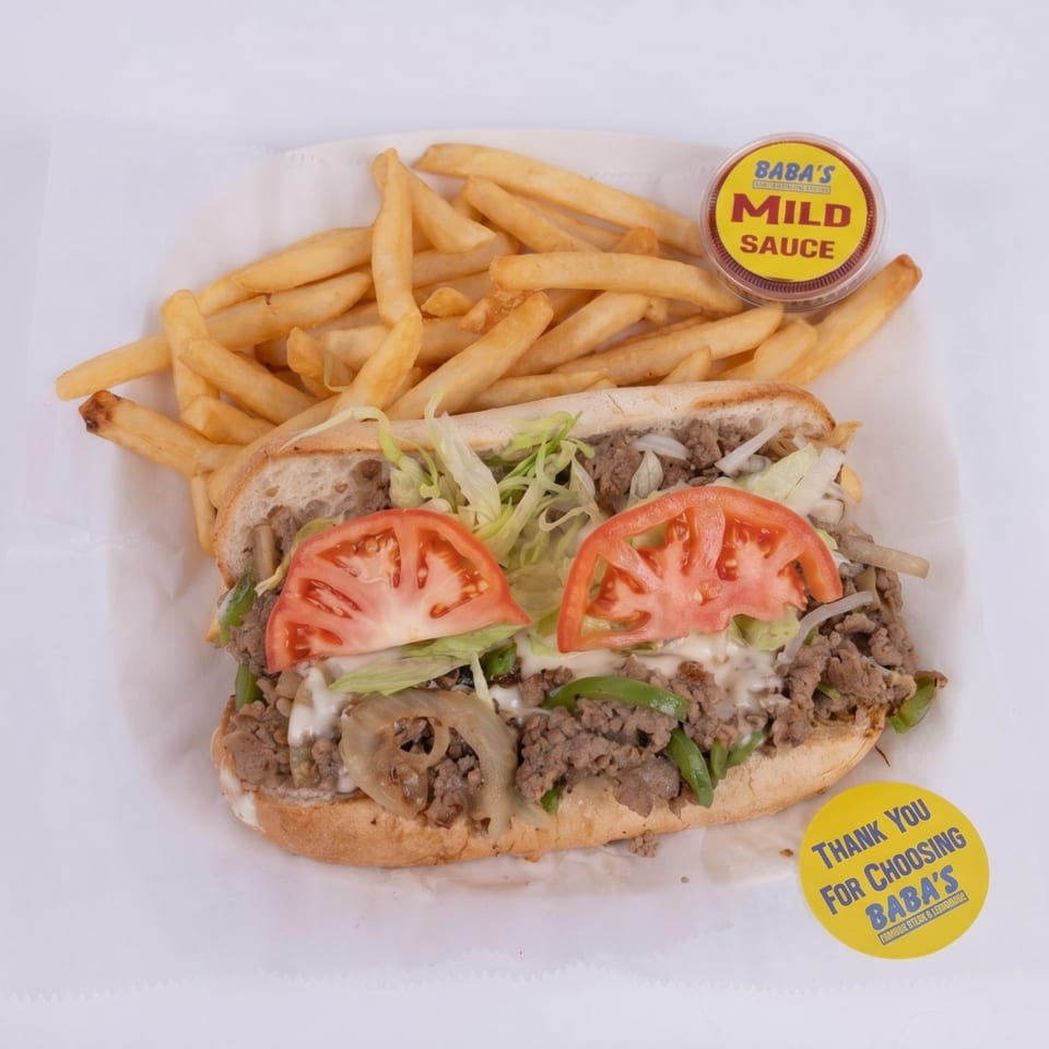 A Baba's cheesesteak with lettuce, tomatoes, onions, and peppers, served with fries and mild sauce.