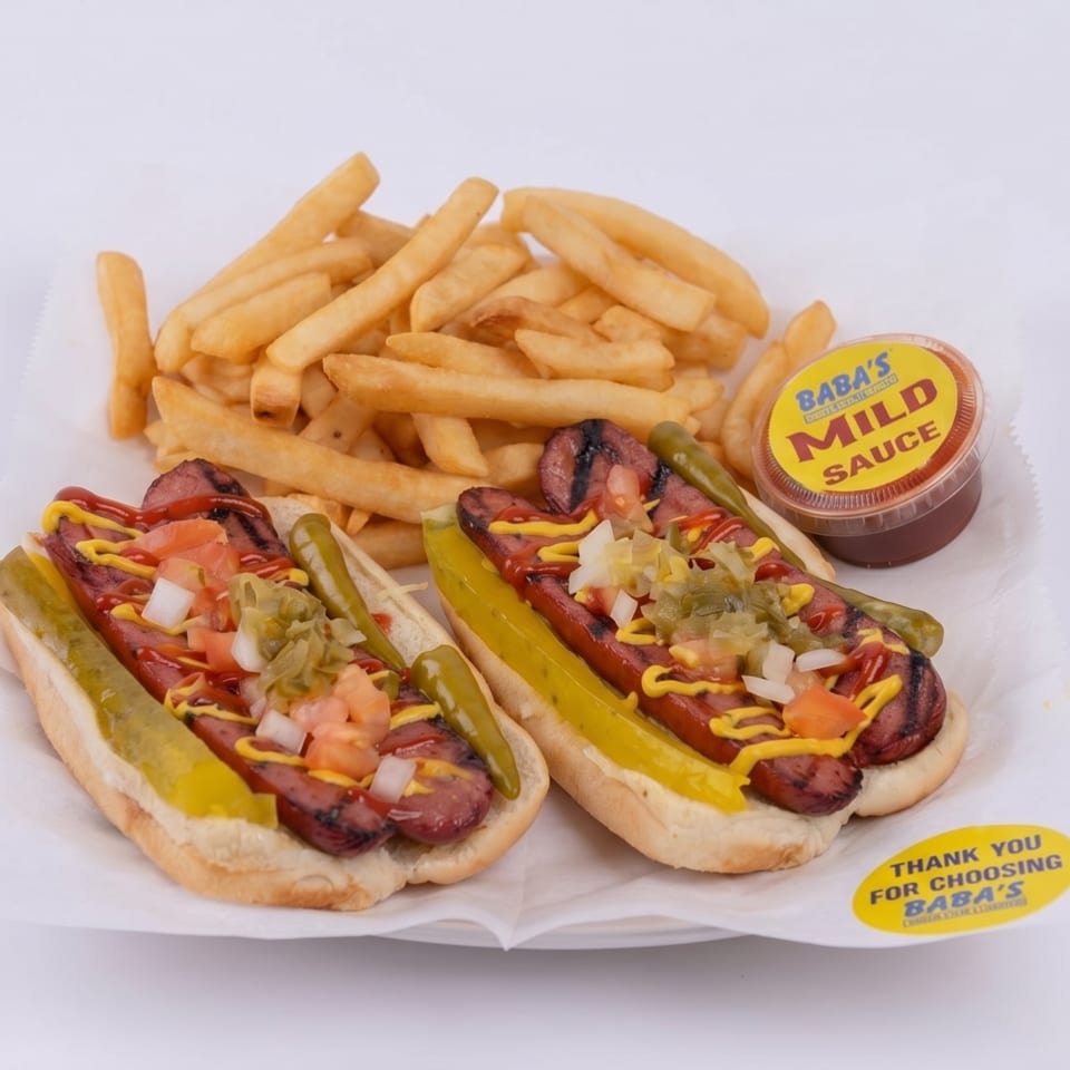 Two Baba's hot dogs with fries and a side of mild sauce on a white paper tray.